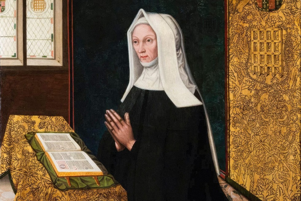 A woman wearing a black dress and white hood, praying in front of a Bible