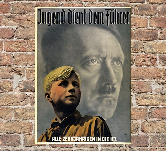 A poster showing a black and white photo of Hitler with a young blond boy in the foreground