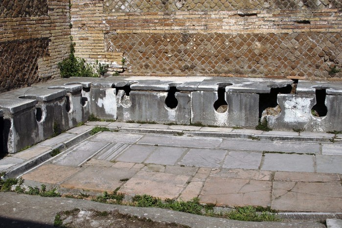 Ostia Antica. Latrine. The remains of this 2nd-century AD latrine show the communal approach to Roman toilets. The site is in the Domus of the Triclinium at Ostia Antica served the guild of builders who worked in the bustling port of Rome.