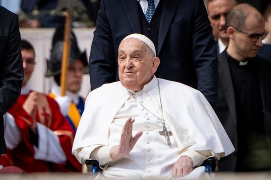 Pope Franics waves to the crowd from a wheelchair