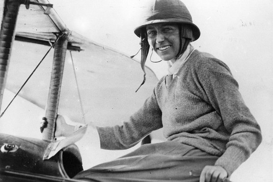 English pilot Amy Johnson sat in a plane and wearing a helmet