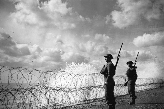 Soldiers guard England's south coast behind a bank of banned wire on 2 September 1940