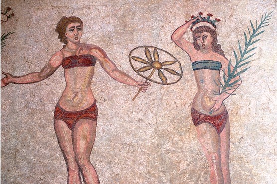 A mosaic that shows two Roman women exercising, one holds a flower and another holds a leaf