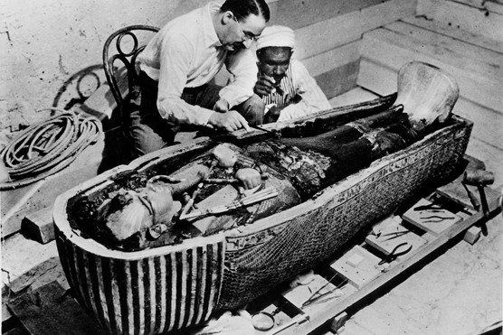 Archaeologist Howard Carter removing oils from the