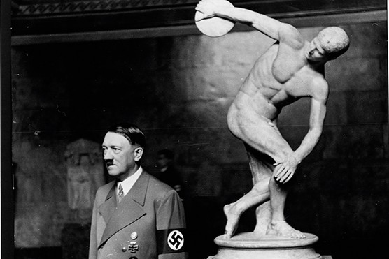 Adolf Hitler stands with his back to a statue of Discobolos, the Discus Thrower