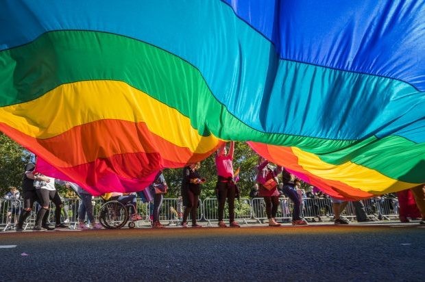 People march with a large rainbow flag in Reykjavik, Iceland. (Image by Photolibrary / Getty Images Plus)