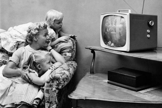 A family watching television in their home, circa 1955.
