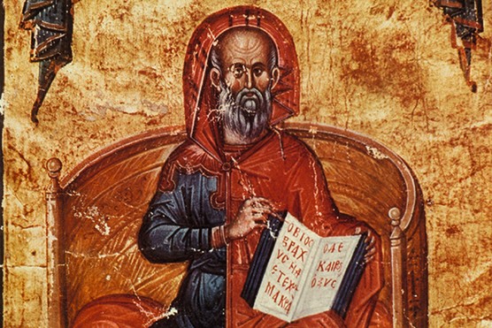 An image of Hippocrates from the 14th century, sitting and holding a book open in front of him