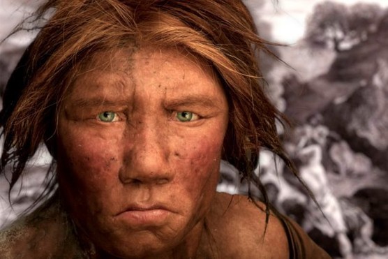 A model of the face of a Neanderthal woman in front of art depicting a prehistoric environment