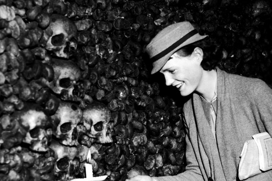 A woman looks on in fascination during a visit to the Paris Catacombs in the mid-1930s. (Photo by Getty Images)