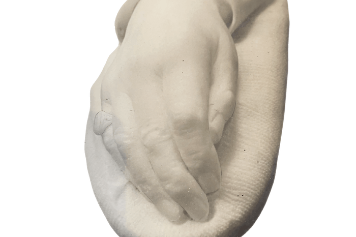 A white stone cast of a man's right hand. On the little finger, there is the a large signet ring